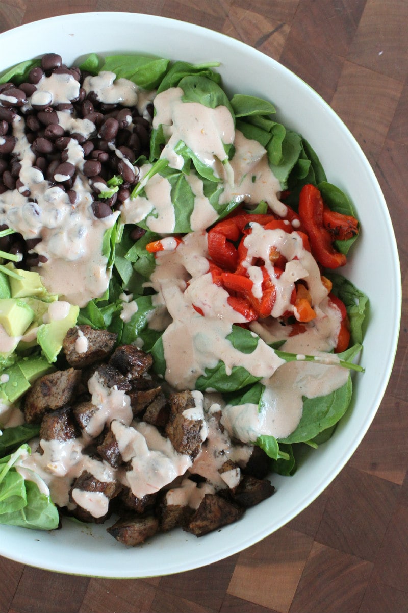 Blackened Steak Salad with dressing drizzled on top