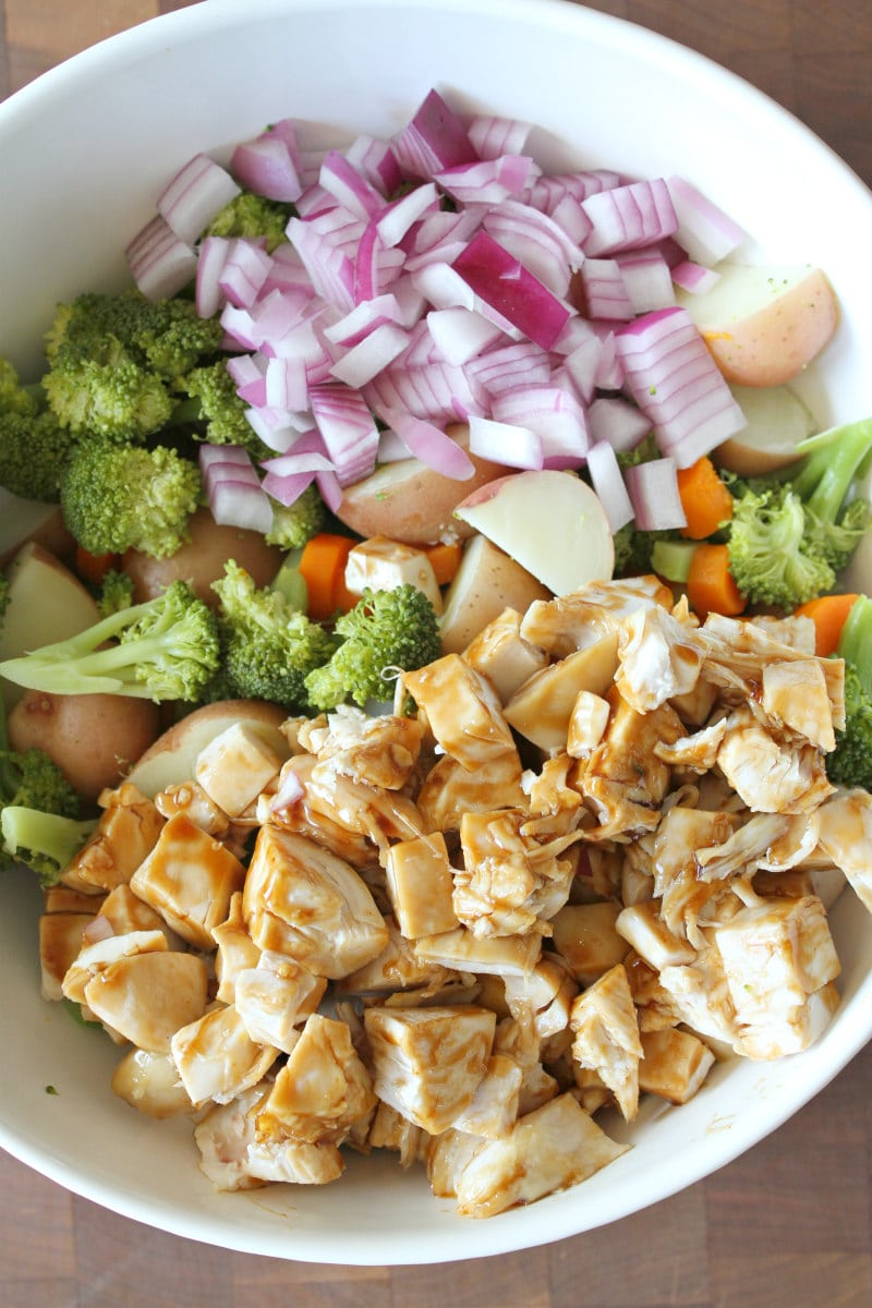 Broccoli and Chicken Salad with Lemon Dressing recipe from RecipeGirl.com #broccoli #chicken #salad #lemon #dressing #recipe #RecipeGirl Making Broccoli and Chicken Salad in white bowl