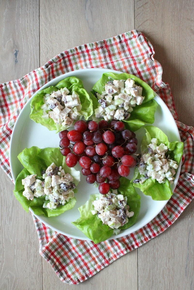 Chicken Apple Salad served in Lettuce Wraps on white plate with red grapes