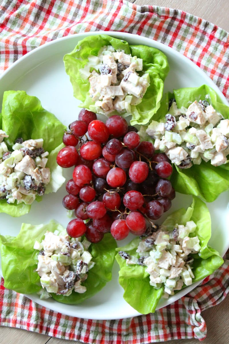 Chicken Apple Crunch Salad served in Lettuce Wraps on white plate with red grapes