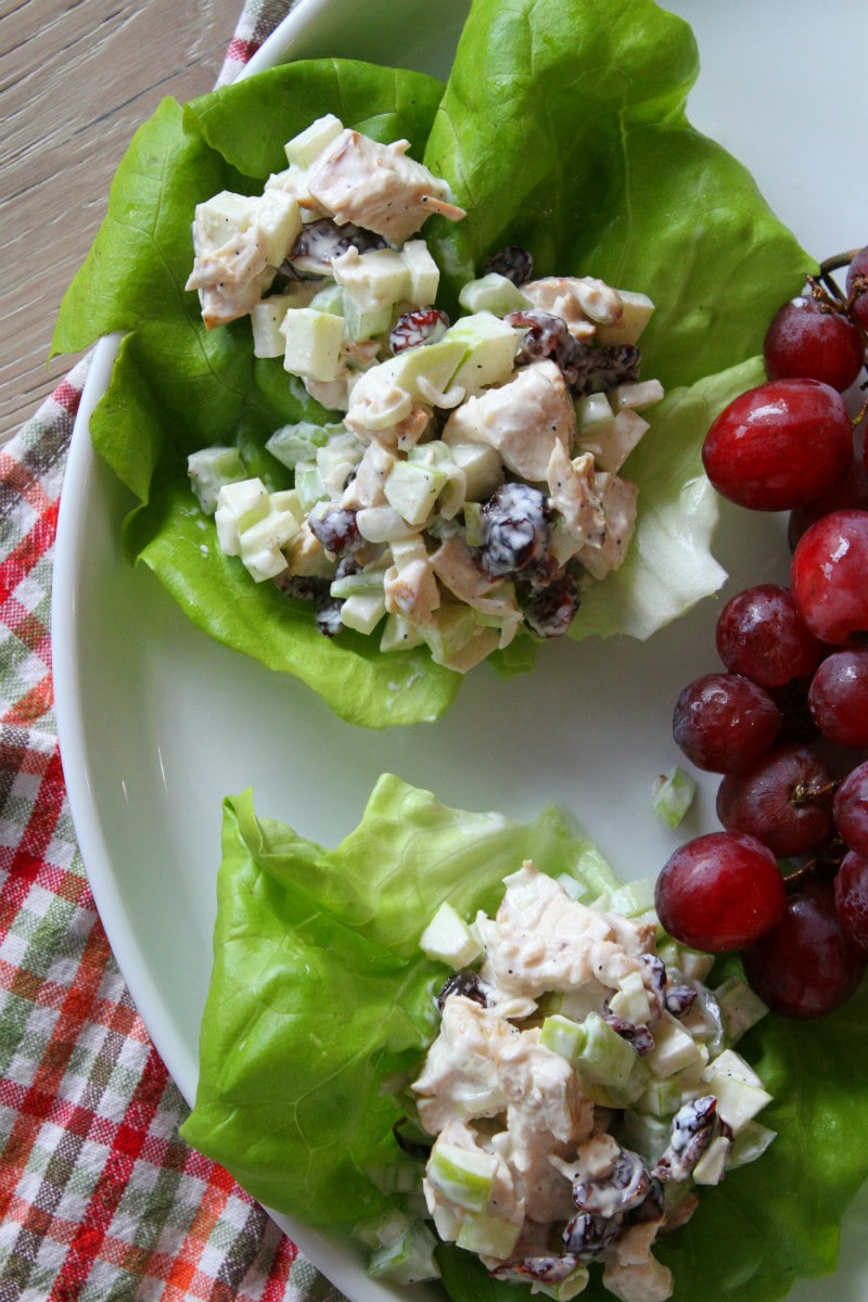 Chicken Apple Salad served in Lettuce Wraps on white plate with red grapes