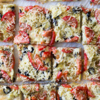 overhead shot of artichoke pizza cut into pieces