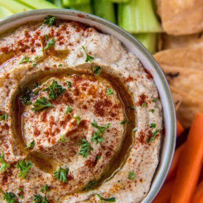 overhead shot of Baba Ghanoush in a bowl served with veggies and pita chips