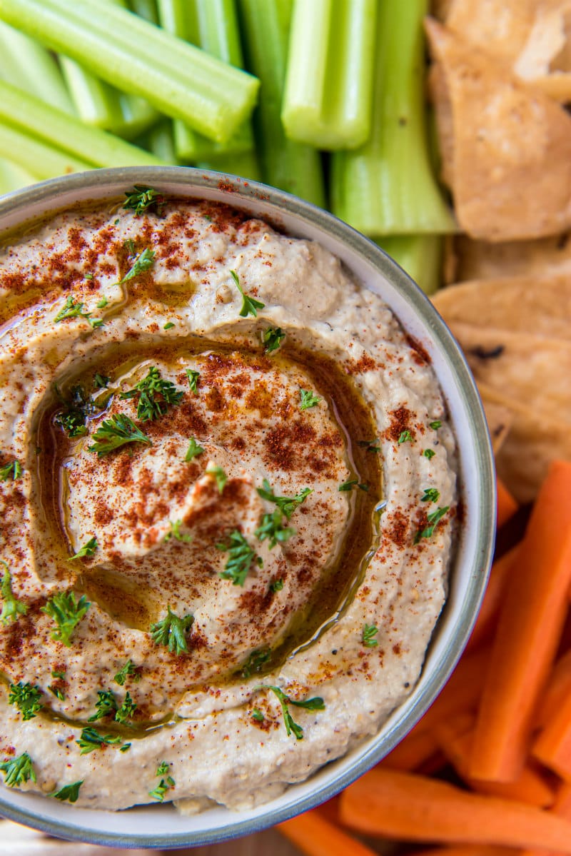 overhead shot of Baba Ghanoush in a bowl served with veggies and pita chips