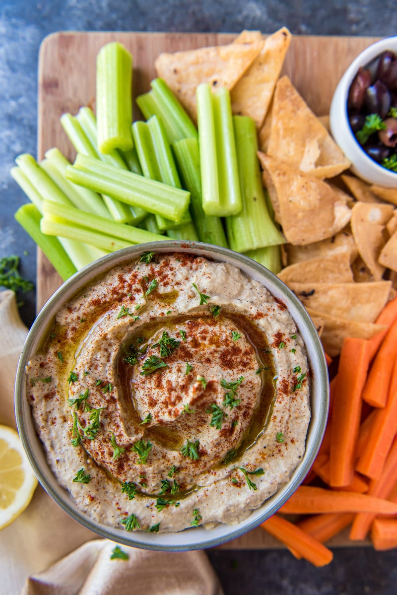 Overhead shot of Baba Ghanoush in a bowl served with celery, carrots and pita chips