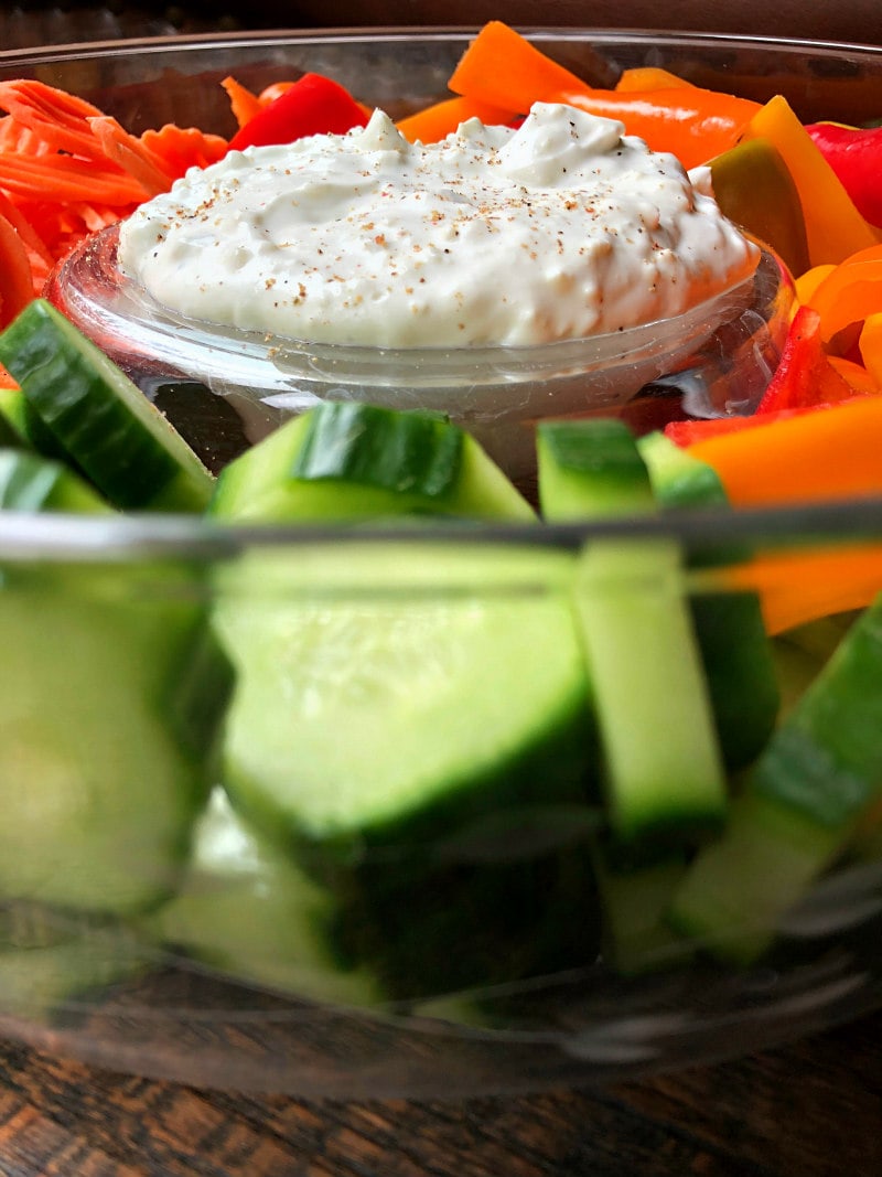 blue cheese dip in a veggie tray with cucumber and carrots