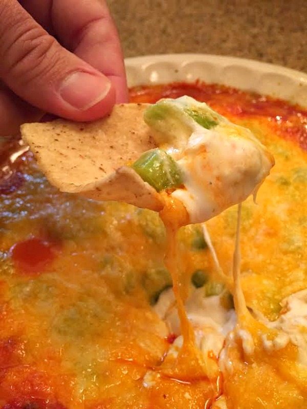 Buffalo Chicken Dip Recipe with hand holding dipped chip