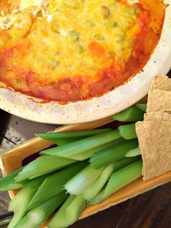 Buffalo Chicken Dip in pan with celery and chips