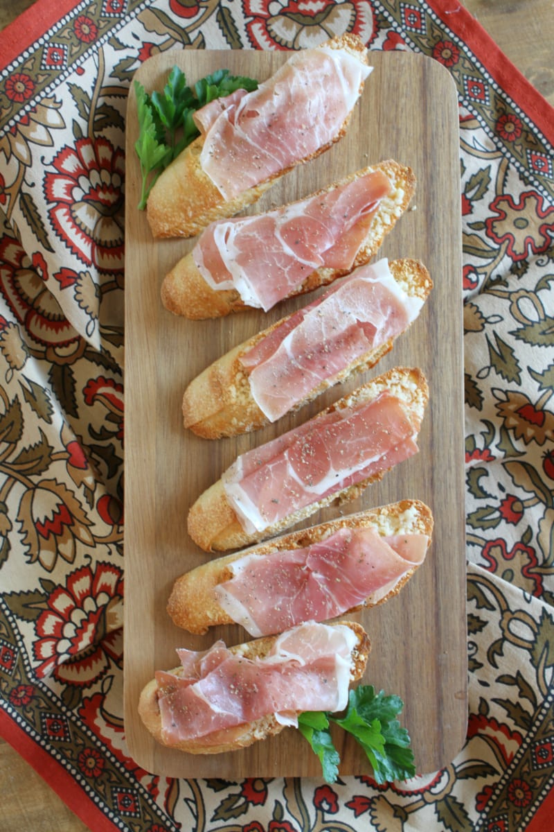 Cheese Crostini with Prosciutto recipe from RecipeGirl.com #cheese #prosciutto #crostini #appetizer #recipe #RecipeGirl cheese crostini with prosciutto on board
