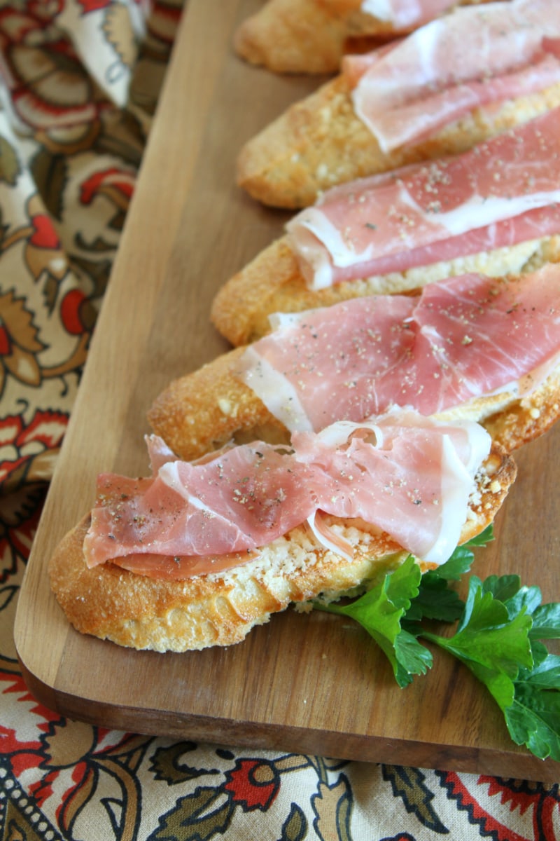 Cheese Crostini with Prosciutto recipe from RecipeGirl.com #cheese #prosciutto #crostini #appetizer #recipe #RecipeGirl cheese crostini with prosciutto on board