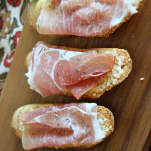 pinterest image for cheese crostini with prosciutto