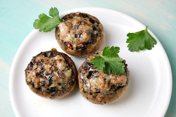 three stuffed mushrooms on a white plate