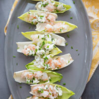 endive with shrimp salad on a gray platter