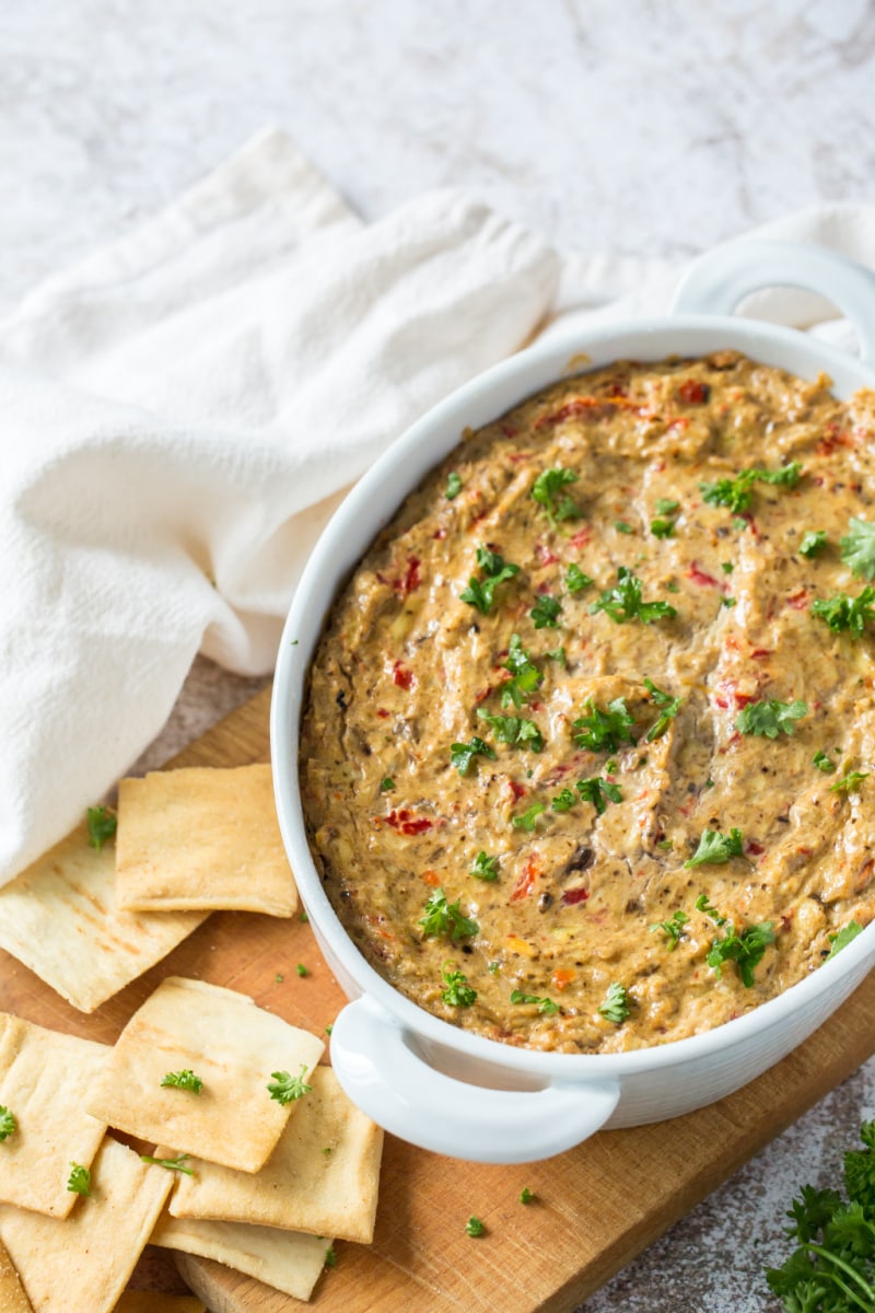 white baking dish with hot artichoke dip in it