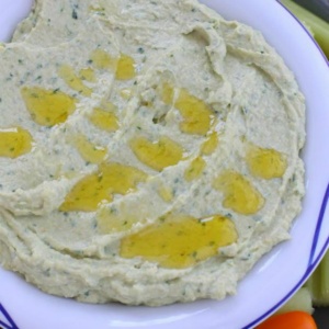 hummus with olive oil drizzled on top in white bowl