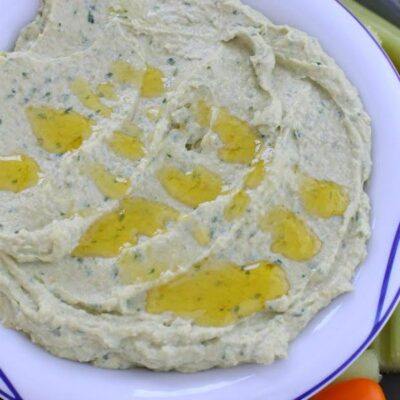 hummus with olive oil drizzled on top in white bowl