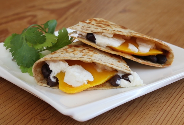 Mango Black Bean and Goat Cheese Quesadilla slices on a white plate
