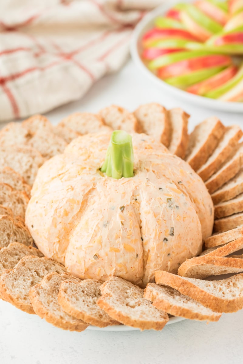 pumpkin cheese ball surrounded by baguette and apple slices