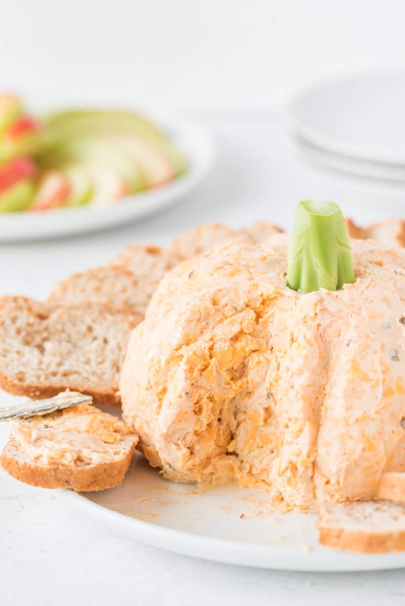 pumpkin cheese ball cut into with baguette slices