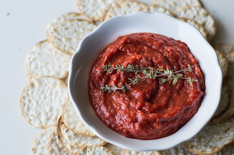 roasted sweet red pepper spread in white dish surrounded by crackers