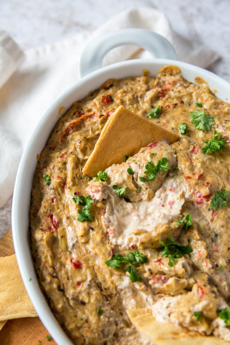 white baking dish with hot artichoke dip