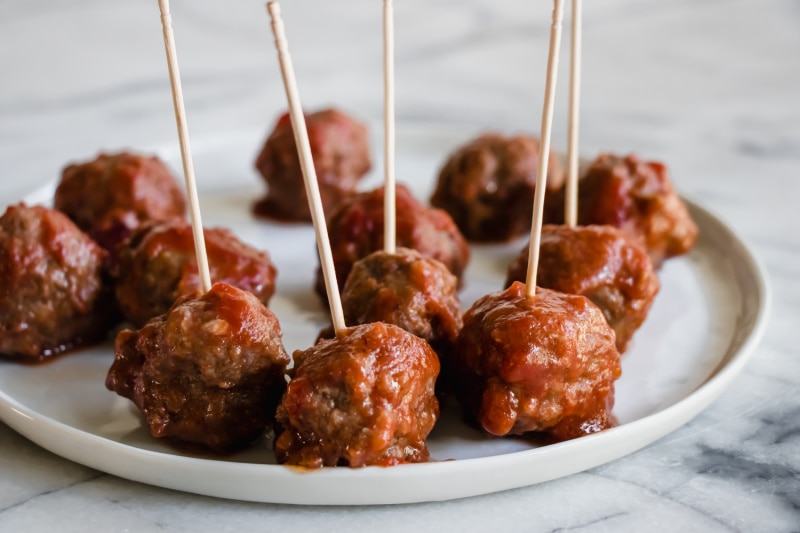 Sweet and Sour Meatballs appetizer recipe from RecipeGirl.com #sweet #sour #sweetandsour #meatballs #recipe #RecipeGirl meatballs on a serving plate with toothpicks