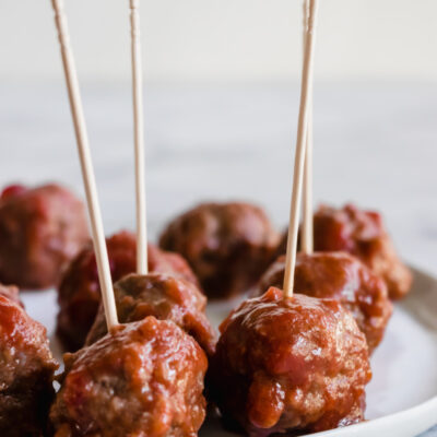 sweet and sour meatballs on a plate with toothpicks