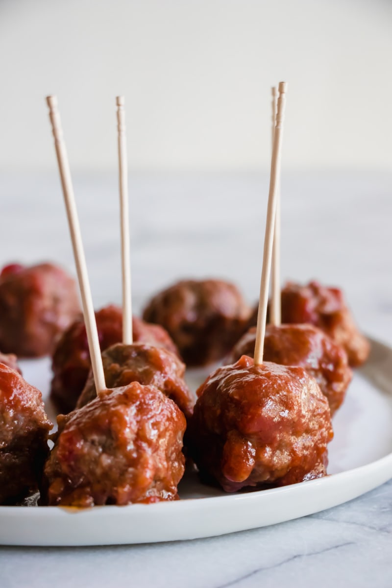 sweet and sour meatballs on a plate with toothpicks