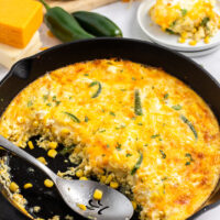 spooning cheese souffle out of cast iron skillet