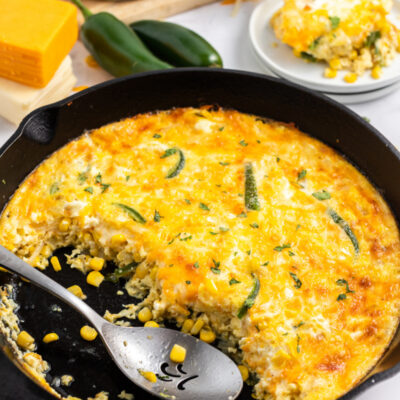 spooning cheese souffle out of cast iron skillet