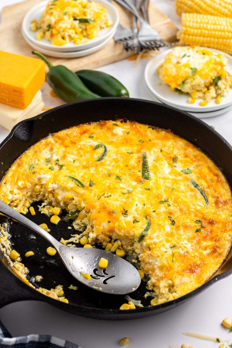 spooning cheese souffle out of cast iron skillet