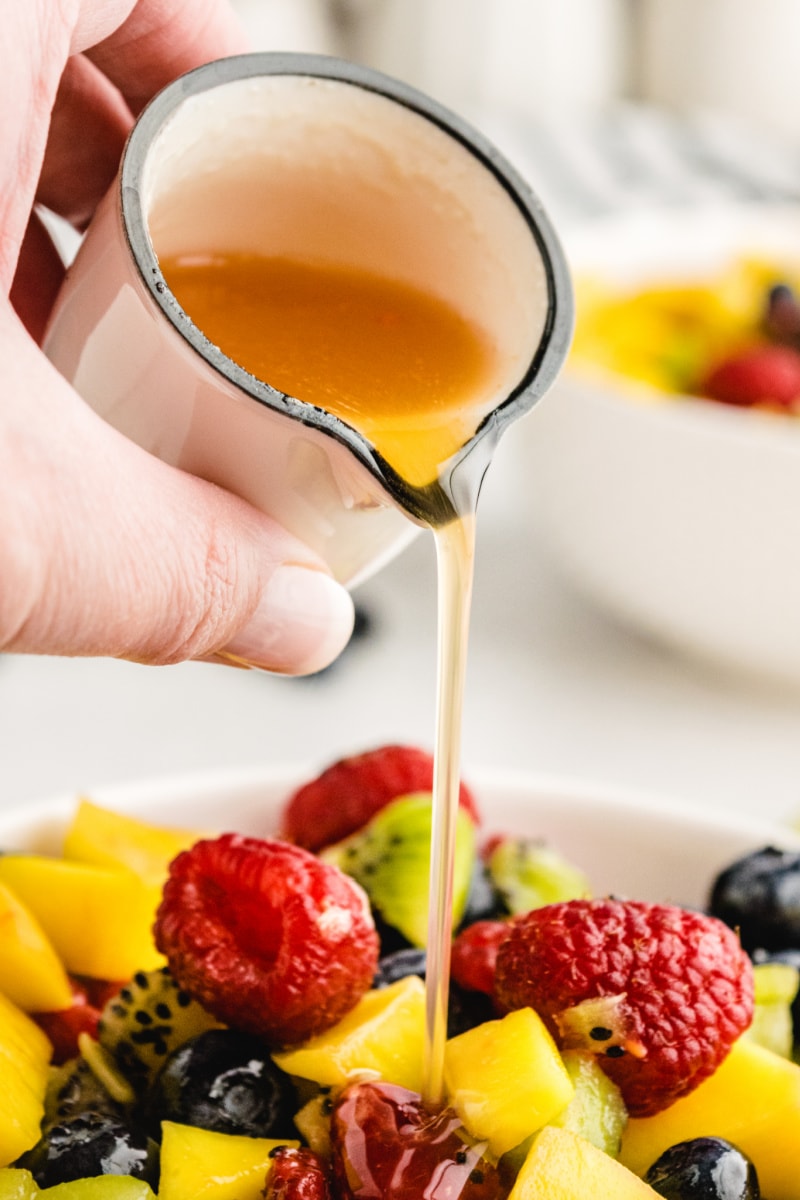 pouring dressing onto fruit salsa