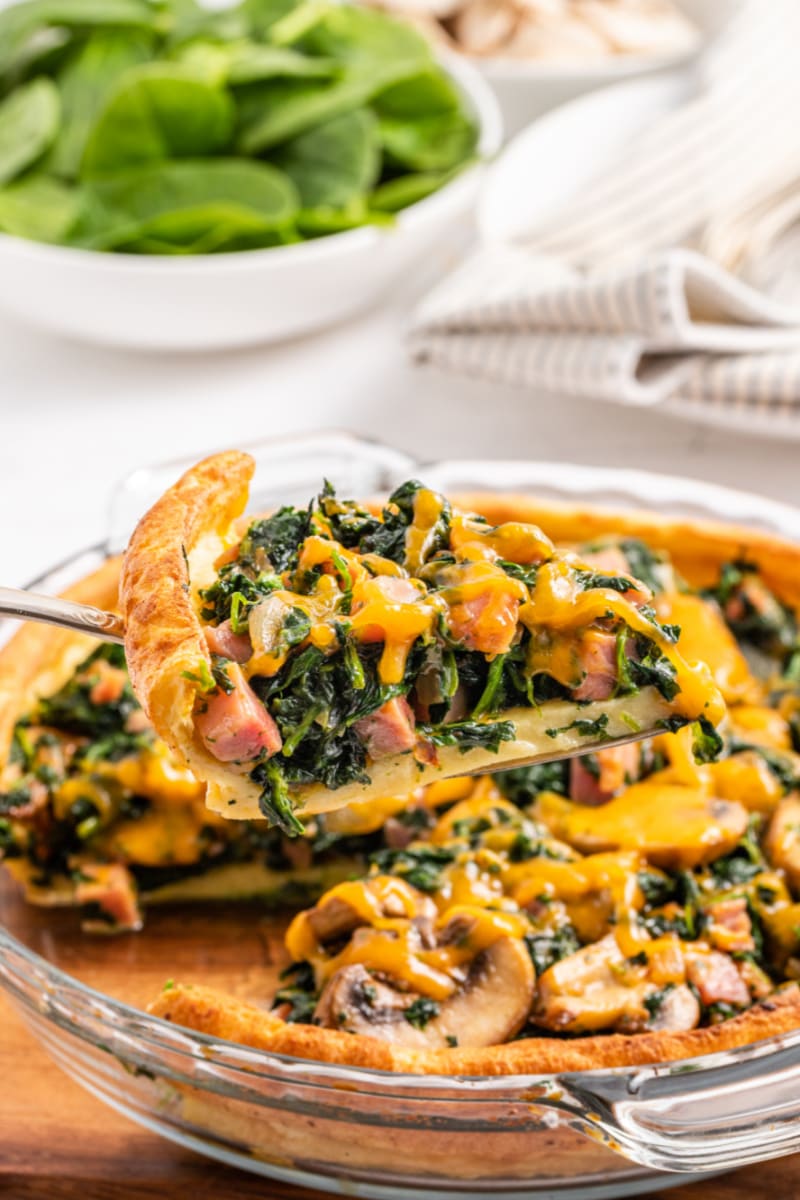 spatula taking out slice of ham and spinach puff pancake