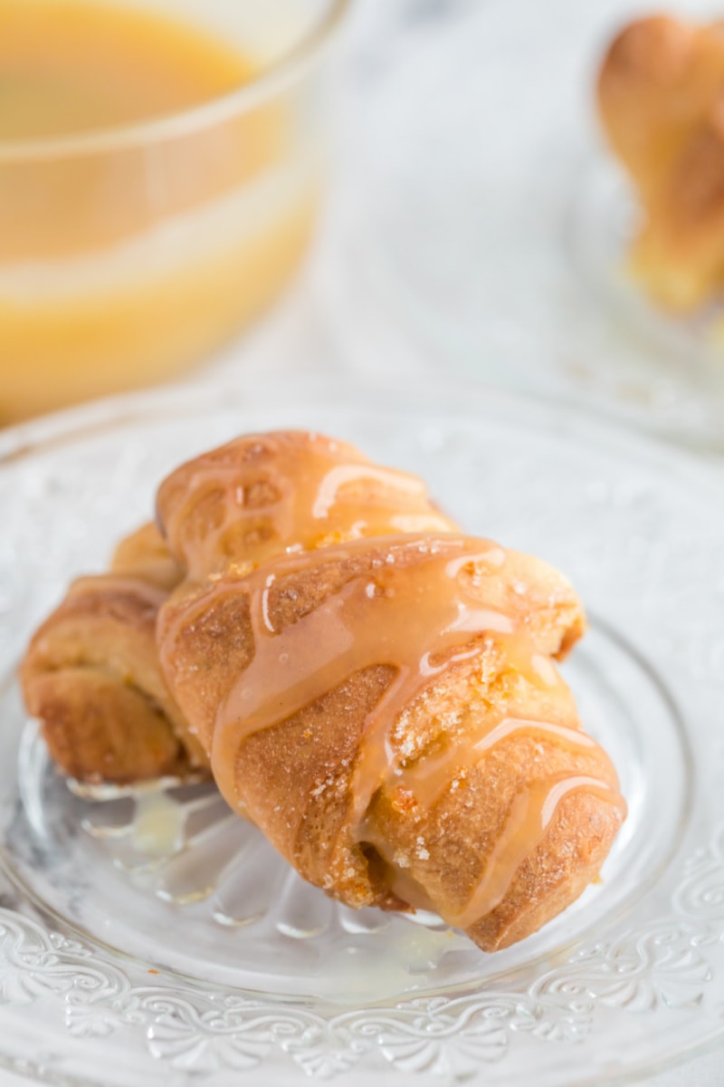 orange sticky buns on a plate with glaze