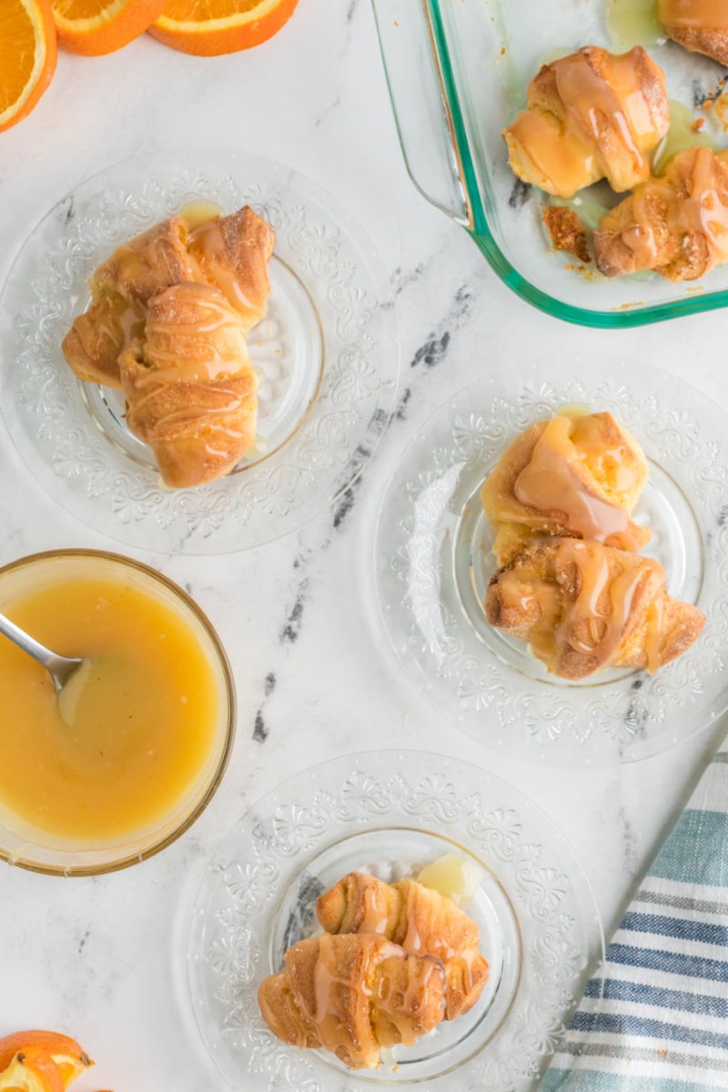 orange sticky buns on plates with glaze