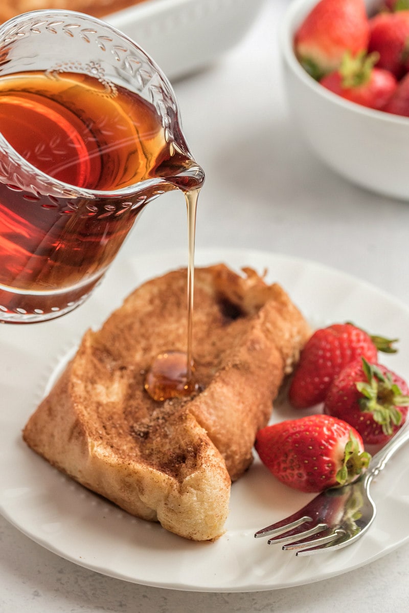 pouring syrup onto french custard toast with strawberries
