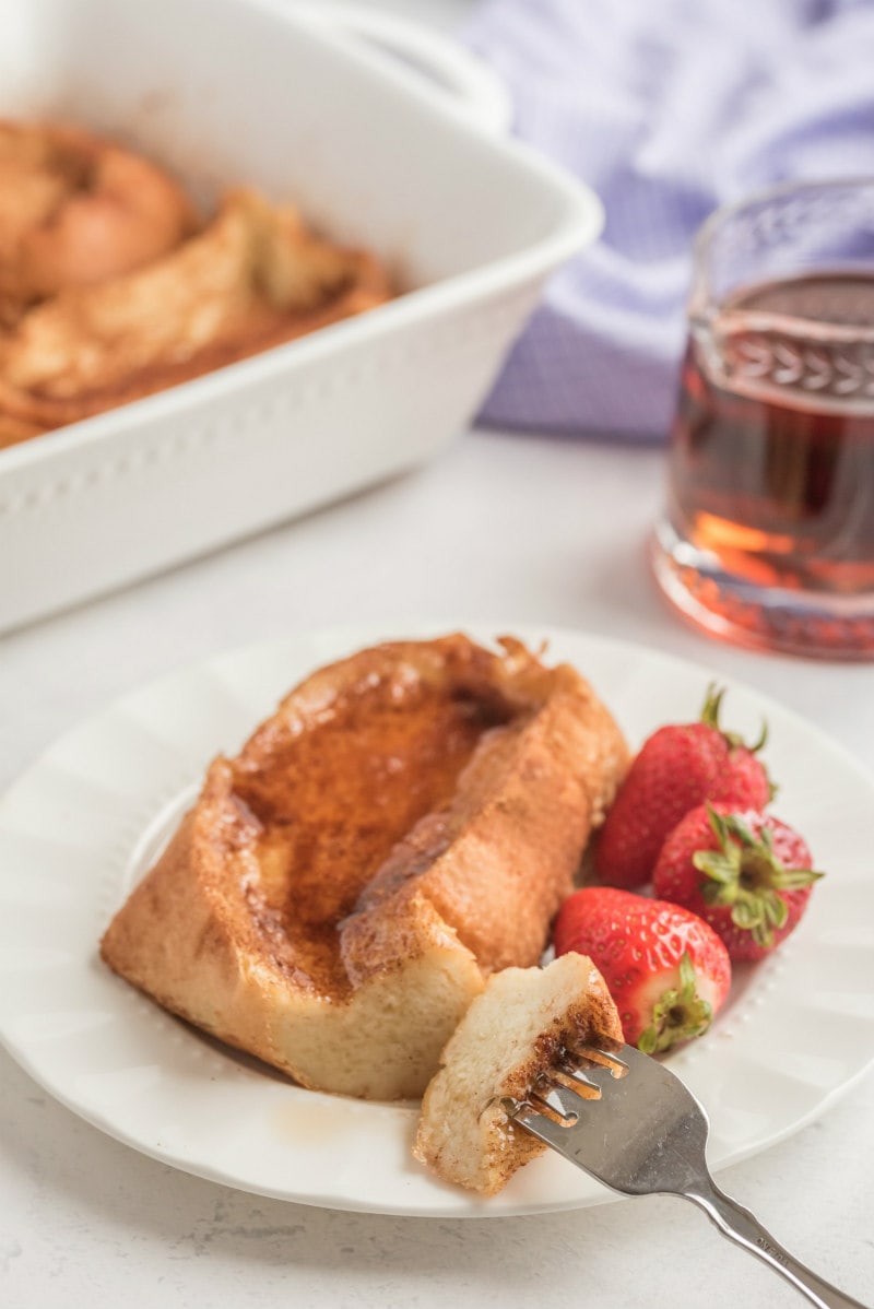 fork cutting up french custard toast with syrup