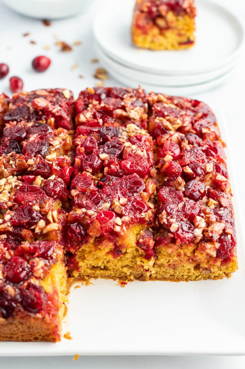 pumpkin cranberry upside down cake cut into slices on white platter