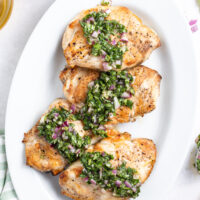 grilled chicken with basil chimichurri on a white platter