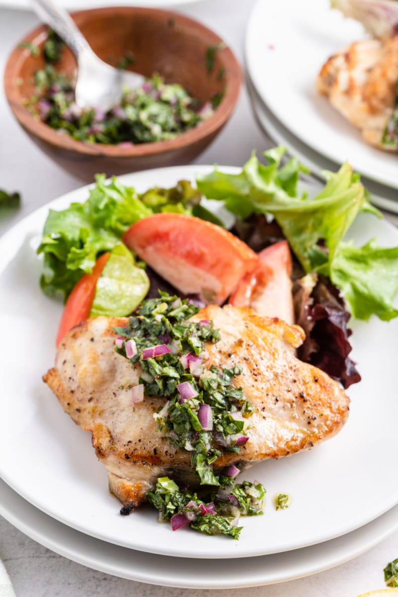 grilled chicken with basil chimichurri on a plate with salad