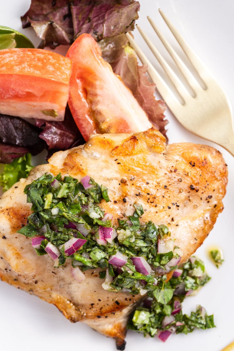 grilled chicken with basil chimichurri on a plate with a fork
