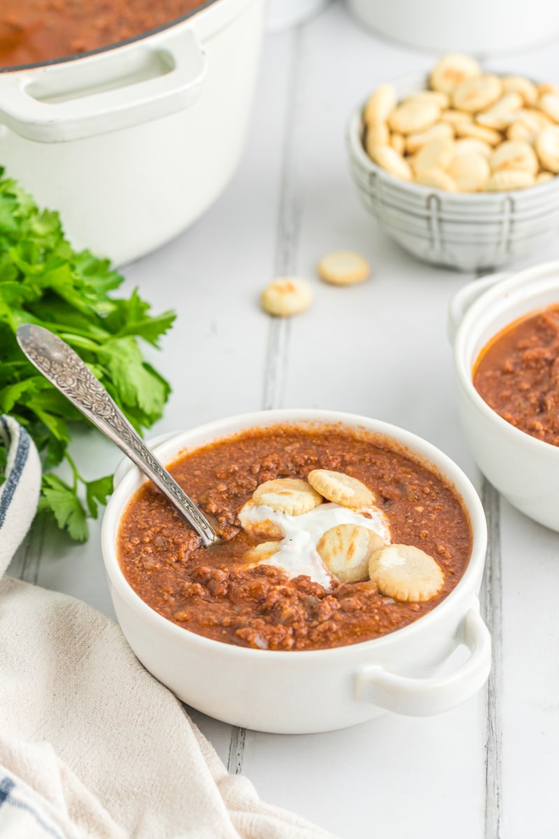 bowl of chili with sour cream and crackers