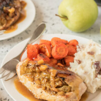 chicken breasts with curried apple stuffing on a plate with potatoes and carrots