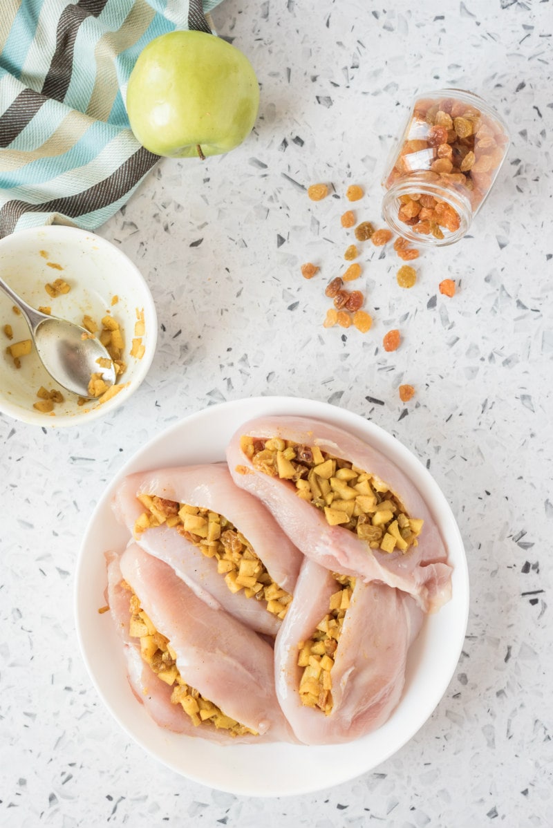 raw chicken breasts stuffed with curried apple stuffing on plate