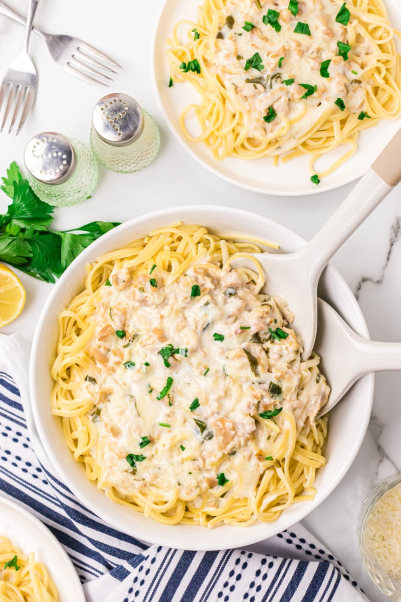 dishing out clam linguine from bowl