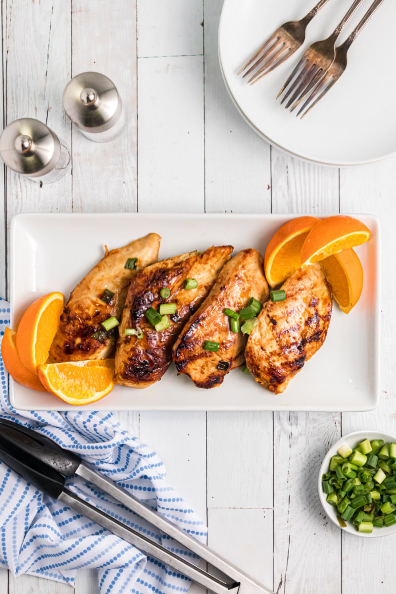 grilled citrus garlic chicken on a plate with oranges