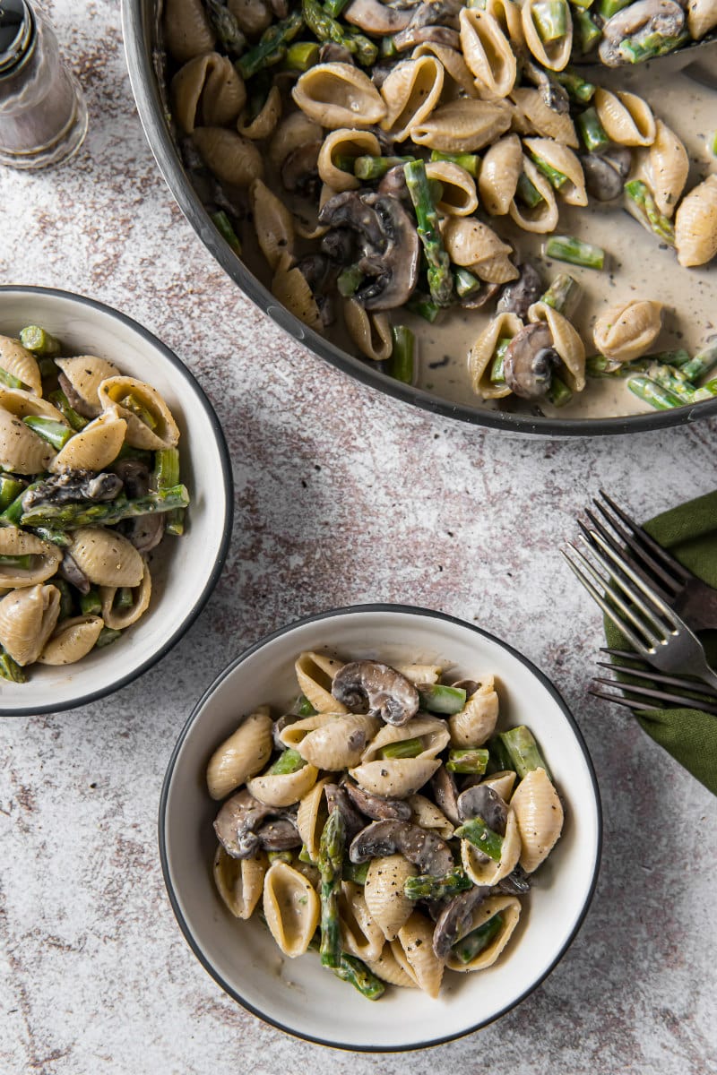 pan of pasta shells with boursin sauce with two servings in white bowls