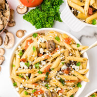 bowl of penne with mushrooms tomato and gorgonzola cheese