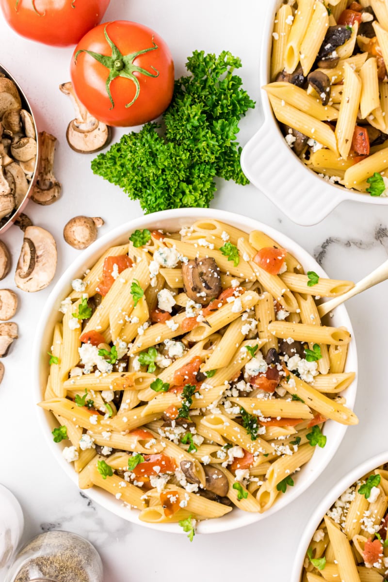 bowl of penne with mushrooms tomato and gorgonzola cheese