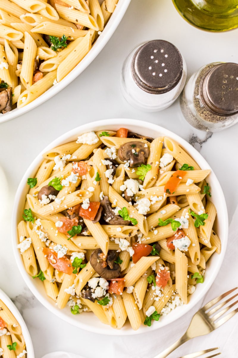 bowl of penne with mushrooms tomato and gorgonzola cheese